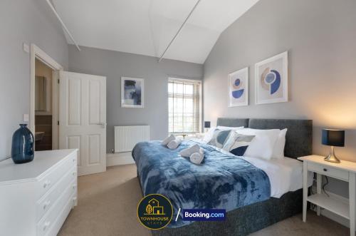 ein Schlafzimmer mit einem großen Bett mit einer blauen Decke in der Unterkunft 4BR Contractor House by Townhouse Stays, Short Lets & Serviced Accommodation in Colchester Free Parking, Garden & WiFi in Lexden