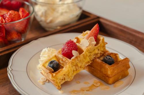 two waffles with strawberries and blueberries on a plate at The St. Regis Shenzhen Bao'an in Shenzhen