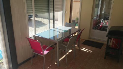 - une table à manger avec des chaises et un plateau en verre dans l'établissement Brétignolles-sur-Mer, maison bord de mer, à Bretignolles-sur-Mer