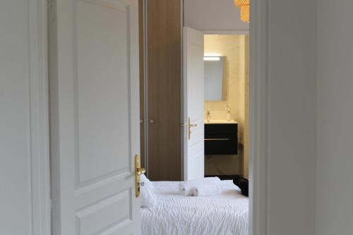 una camera da letto con un letto bianco e uno specchio di Résidence Montana Le Mans a Le Mans