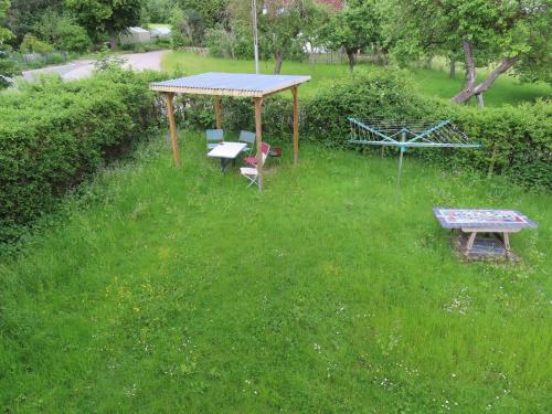 a picnic table and a bench in a field of grass at Monteurwohnung bei Crailsheim Feuchtwangen in Fichtenau