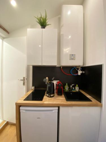 une cuisine avec des armoires blanches et un évier dans l'établissement Studio cosy hypercentre de Toulouse, à Toulouse