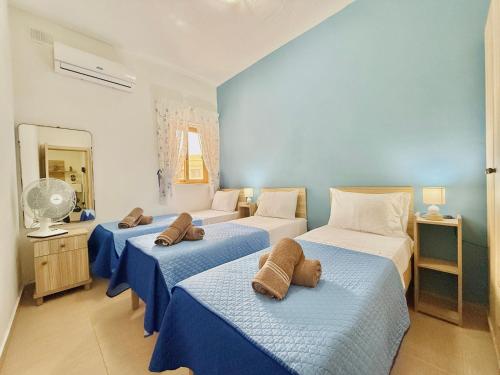 パオーラにあるApartment in South Part Maltaのベッドルーム(青と白のベッド3台付)