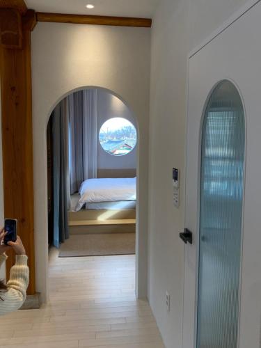a bedroom with a bed and a hallway with a mirror at Gyeong-ju Stayangim in Gyeongju