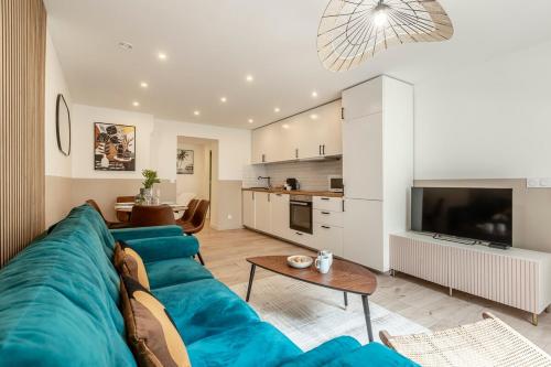 un salon avec un canapé bleu et une cuisine dans l'établissement 11#Opera#Grands Boulevards#Paris02#AC, à Paris