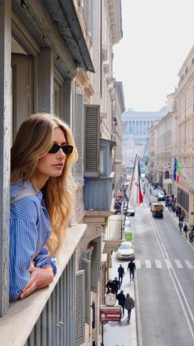 a woman standing on a ledge looking out of a window at The Couper Umiltà in Rome