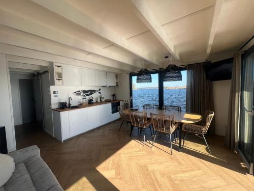 a kitchen and dining room with a table and chairs at Surla Houseboat "Walvis" Kagerplassen in Buitenkaag