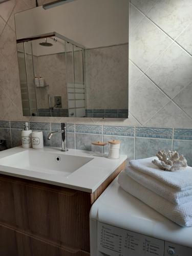a bathroom with a sink and a mirror at Abba Sixty - View, Pool & Parking - 200mt Sea in Tertenìa