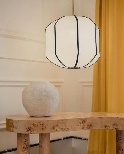 a vase sitting on a wooden table under a lamp at The Couper Umiltà in Rome