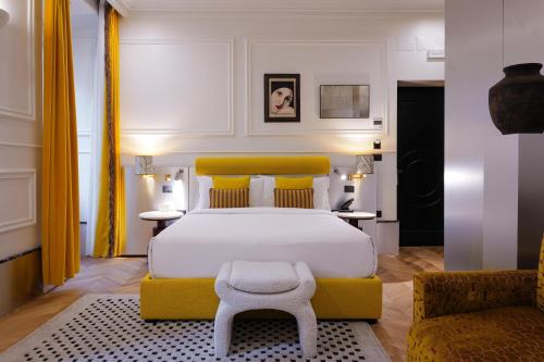 a bedroom with a large bed and a yellow couch at The Couper Umiltà in Rome