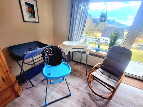 une chambre avec un lit, une chaise et une table dans l'établissement Charmante, familienfreundliche Ferienwohnung im Herzen der Vulkaneifel, à Niederstadtfeld