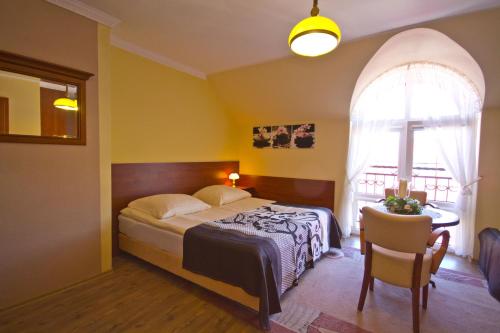 a bedroom with a bed and a table and a window at Villa Tropikana in Łeba