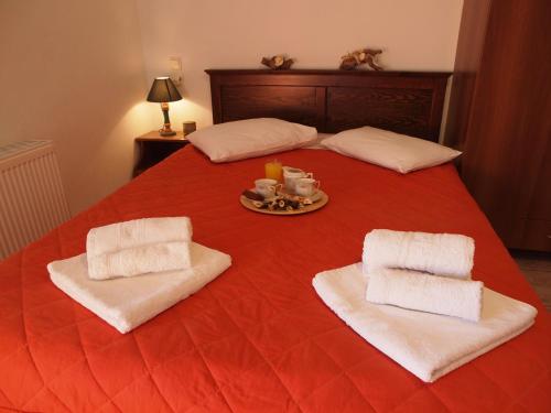 a red bed with two pillows and a plate of food at Andromahi Studios in Lefokastro