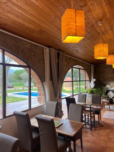 a dining room with tables and chairs and windows at Hotel & Golf Ca La Caputxeta - Adults Only in Roses