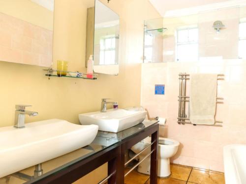 a bathroom with two sinks and a toilet at The Star Guest House in Witbank