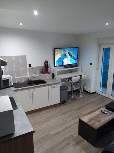 Il comprend une cuisine dotée d'une télévision murale blanche. dans l'établissement apartment with terrace, à Belfort