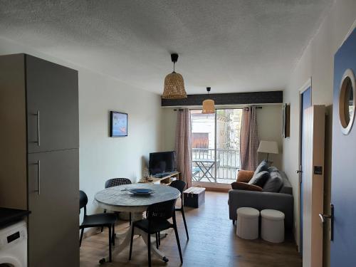 un salon avec une table et un canapé dans l'établissement Centre ville d'Arcachon - app 5 couchages - parking, à Arcachon