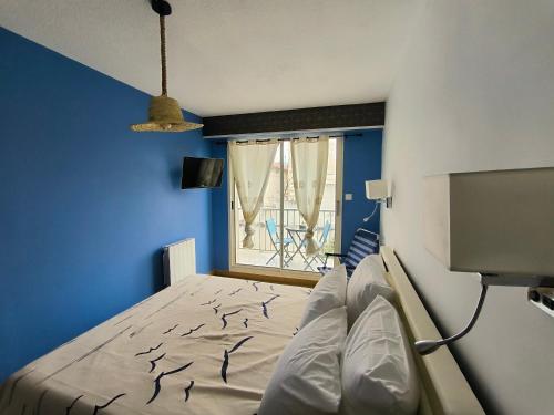 une chambre avec un lit aux murs bleus et une fenêtre dans l'établissement Centre ville d'Arcachon - app 5 couchages - parking, à Arcachon