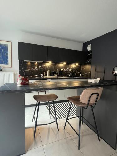 une cuisine avec deux tabourets de bar et un comptoir dans l'établissement Studio proche du centre ville et du Parlement Européen, à Schiltigheim