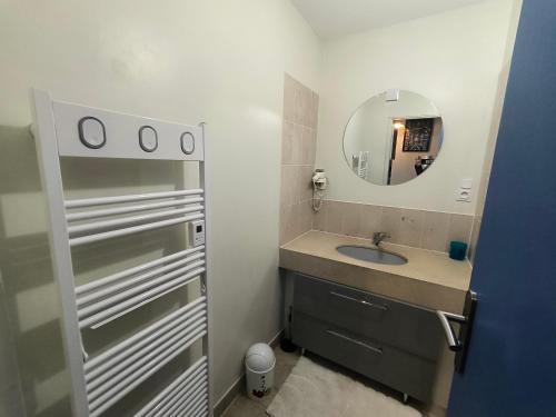 une salle de bain avec un lavabo et un miroir dans l'établissement Centre ville d'Arcachon - app 5 couchages - parking, à Arcachon