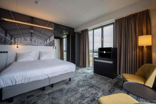 ein Hotelzimmer mit einem Bett und einem TV in der Unterkunft Fletcher Wellness-Hotel Helmond in Helmond