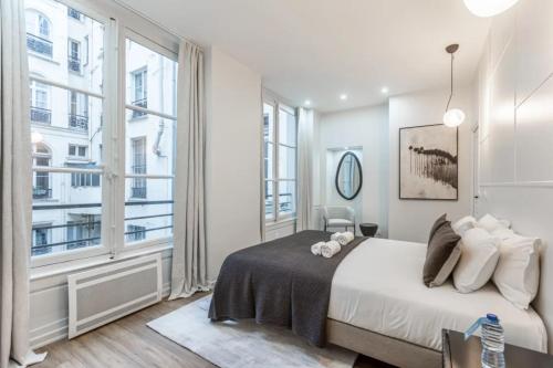 une chambre avec un lit et une grande fenêtre dans l'établissement 21#Opera#Louvre#Paris02#2bedrooms#AC, à Paris