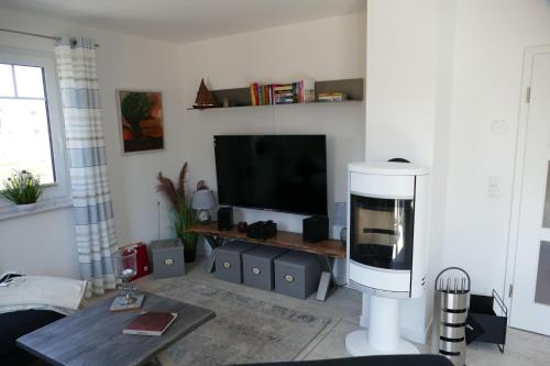 a living room with a television and a table at Ferienhaus In Mellnitz Mit Großem Garten in Poseritz