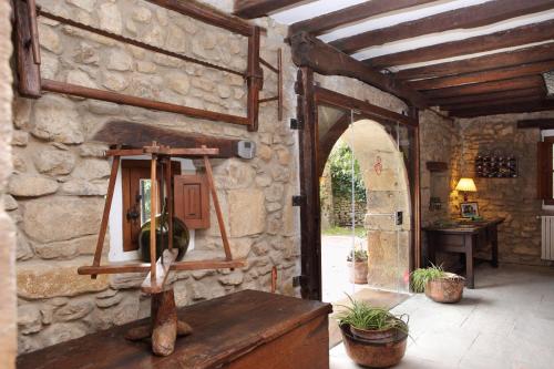 um quarto com uma parede de pedra e uma entrada em Posada La Torre de La Quintana em Liendo