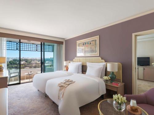 a hotel room with two beds and a balcony at Rixos Downtown Antalya - The Land Of Legends Access in Antalya
