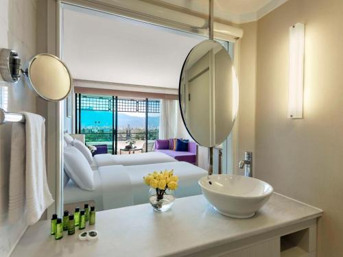 a bathroom with a sink and a large mirror at Rixos Downtown Antalya - The Land Of Legends Access in Antalya