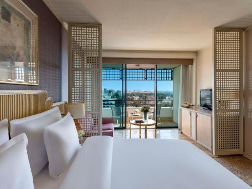 a bedroom with a large white bed and a large window at Rixos Downtown Antalya - The Land Of Legends Access in Antalya