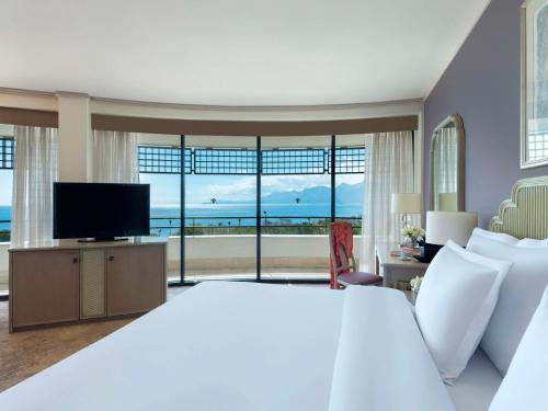 a bedroom with a large bed and a television at Rixos Downtown Antalya - The Land Of Legends Access in Antalya