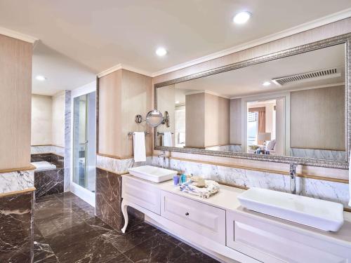 a bathroom with two sinks and a large mirror at Rixos Downtown Antalya - The Land Of Legends Access in Antalya