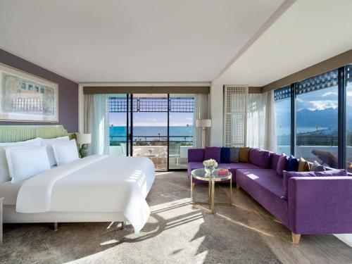 a bedroom with a large bed and a purple couch at Rixos Downtown Antalya - The Land Of Legends Access in Antalya