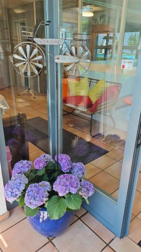 a vase filled with purple flowers in front of a store at Herberge Seeperle Bistro Rorschach in Rorschach