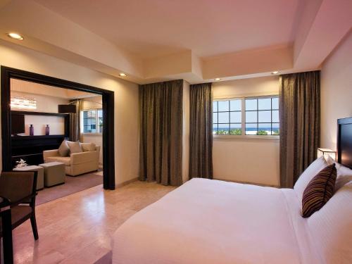 a bedroom with a large white bed and a living room at Move On Beach Resort Al Khobar in Half Moon Bay