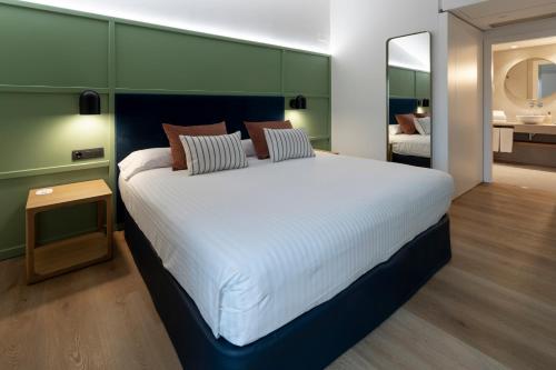 a large white bed in a room with a mirror at Intelier Rosa in Castellón de la Plana