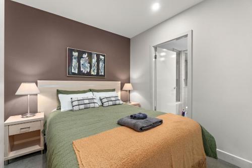 una camera da letto con un letto grande con una coperta verde di Ultima Escapes - Glenelg Beachfront Bliss - Direct Beach Access, Pool, Gym, Free Parking, Wi-Fi a Glenelg