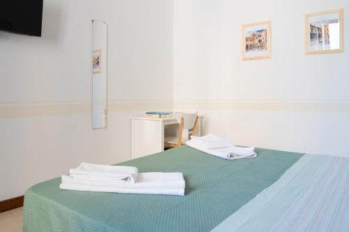 a bed with two white towels on top of it at Ponte Nuovo BB in Verona