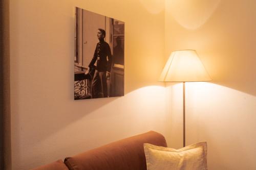 a room with a lamp and a picture of a man at St. Ulrichhof in Lana