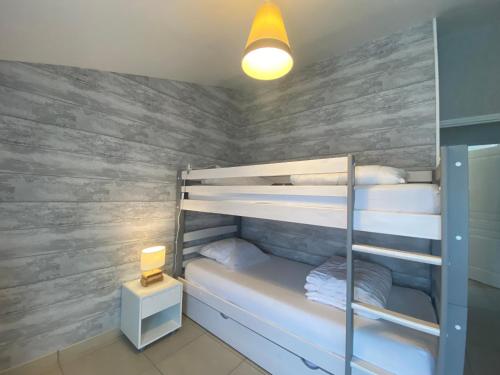 Cette chambre dispose de lits superposés et de murs en bois. dans l'établissement Jolie Villa pour 6 Pers., proche Plage, avec WIFI à La Tranche-sur-Mer - FR-1-22-380, à La Tranche-sur-Mer