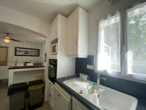 une cuisine blanche avec un évier et une fenêtre dans l'établissement Jolie Villa pour 6 Pers., proche Plage, avec WIFI à La Tranche-sur-Mer - FR-1-22-380, à La Tranche-sur-Mer