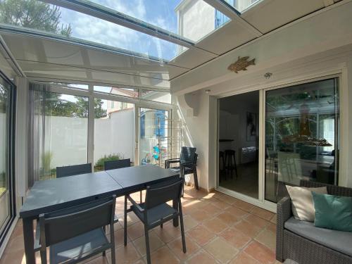 - une salle à manger avec une table, des chaises et des portes en verre dans l'établissement Jolie Villa pour 6 Pers., proche Plage, avec WIFI à La Tranche-sur-Mer - FR-1-22-380, à La Tranche-sur-Mer
