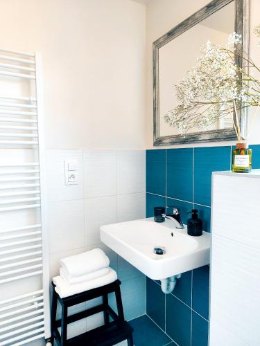 a blue and white bathroom with a sink and a stool at Ateliér 673 in Dolní Bečva
