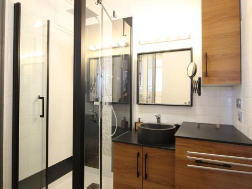 une salle de bain avec un lavabo et une douche en verre dans l'établissement Appartement T2 avec wifi à La Bourboule, proche thermes, jusqu'à 4 personnes - FR-1-608-285, à La Bourboule