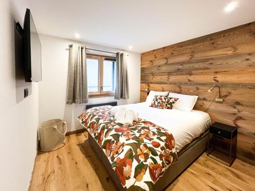 - une chambre avec un lit et un mur en bois dans l'établissement Appartement aux Gets avec Wi-Fi pour 4 personnes - FR-1-671-290, aux Gets