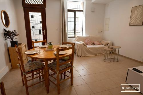 un salon avec une table et un canapé dans l'établissement Maison dans le cœur historique de Vias, à Vias