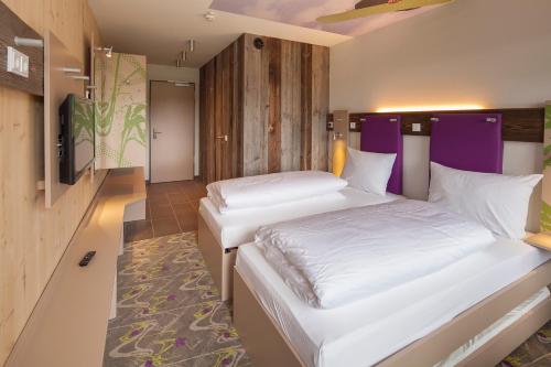 Een bed of bedden in een kamer bij Explorer Hotel Kitzbühel