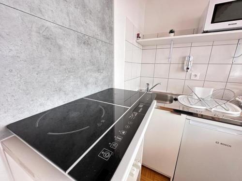 Il comprend une cuisine équipée d'un four et de plaques de cuisson. dans l'établissement Le pilier un cocon en duplex proche centre ville, à Reims