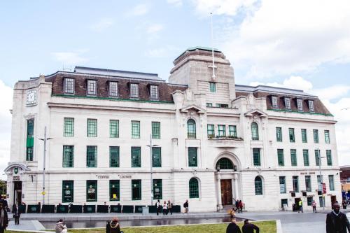 a white building with people walking in front of it at Simple Stay in London